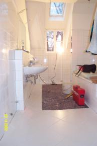 Endmontage des Bades mit Doppelwaschtisch, Badewanne und hinter der Mauer das WC